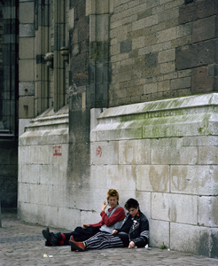 118815 Afbeelding van twee punkmeisjes zittend aan de voet van de Domtoren (Domplein) te Utrecht.
